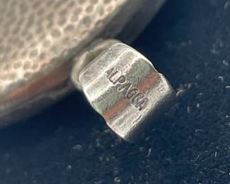 Closeup of clasp on vintage silver locket with young girl's silhouette on front