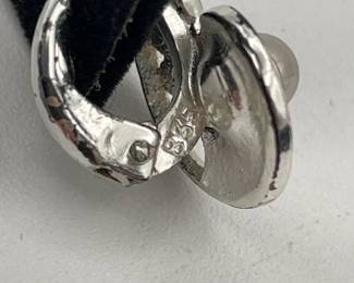 Closeup of pair of silver (835) filigree earrings with pearl