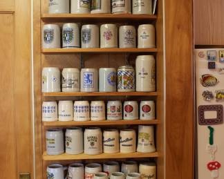 Impressive collection of branded beer steins—some from world fairs and Oktoberfests—including Lowenbrau, Lufthansa, Dinkel Acker, Becks, Schwaben Brau, and more