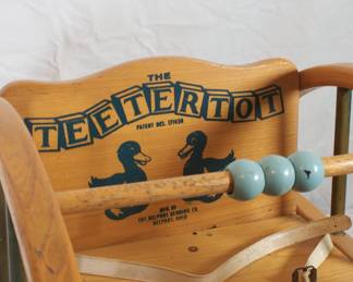 Closeup of vintage wooden The Teetertot child's toddler bouncy seat rocking chair with bead bar, by the Delphos Bending Co., Ohio