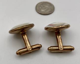 Another view of pair of cufflinks in gold tone metal, with red fishing flies inside clear dome 
