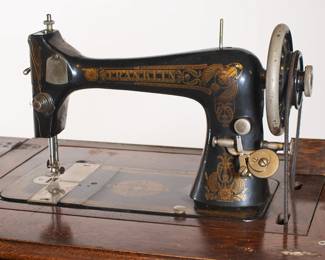 Antique Franklin treadle sewing machine early 1900s, housed in a wooden sewing cabinet 