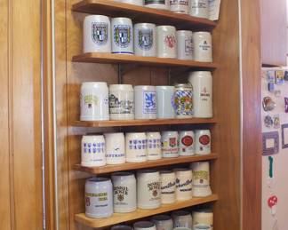 Impressive collection of branded beer steins—some from world fairs and Oktoberfests—including Lowenbrau, Lufthansa, Dinkel Acker, Becks, Schwaben Brau, and more