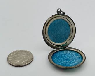 Closeup of interior of antique silver floral guilloche enamel locket with roses