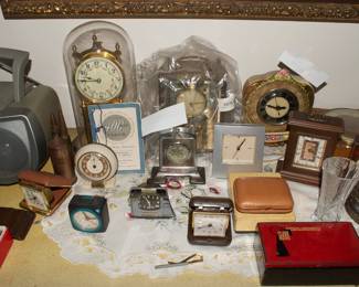 Another view of several vintage mantle clocks and  travel clocks, crystal dishes, vase, trinket boxes
