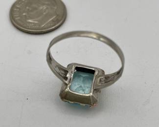 Closeup of 10kt white gold ring with  cushion cut aquamarine colored stone