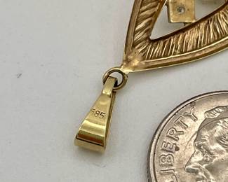 Closeup of 14kt gold pendant with diamond and pearl