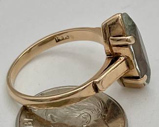 Closeup of 14kt gold ring set with faceted marquise shaped aquamarine color stone