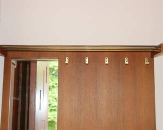 Closeup of hall / entryway unit with mirror, coat rack, shelf, cabinets