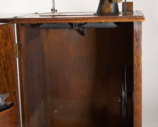 Antique Franklin treadle sewing machine early 1900s, housed in a wooden sewing cabinet 