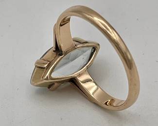 Closeup of 14kt gold ring set with faceted marquise shaped aquamarine color stone