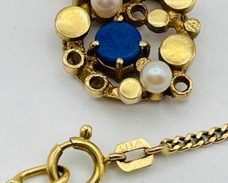 Closeup of 8kt gold necklace with pendant