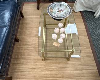 Brass and glass coffee table on bamboo grass rug