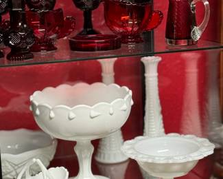 Collection of red and white glassware, including goblets and decorative bowls, featuring intricate patterns and designs.