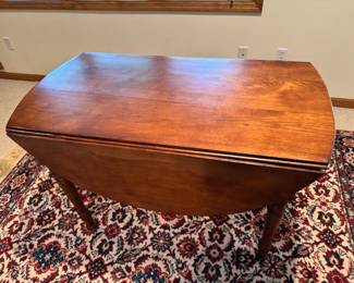 Antique cherry wood drop leaf dining table with wood wheels