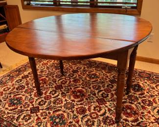 Antique cherry wood drop leaf dining table with wood wheels