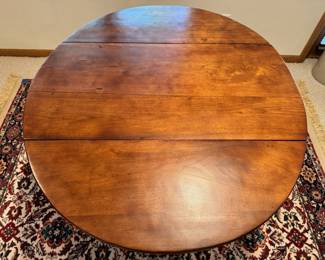 Antique cherry wood drop leaf dining table with wood wheels