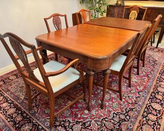 Beautiful antique mahogany wood dining set.  The table measures 42” wide x 62” deep, and extends to 98” with the three 12” leaves.  This table comes with a full set of table pads