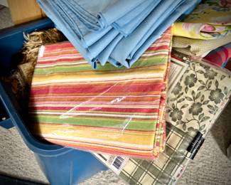 Pine armoire filled with linens (tablecloths, runners, napkins, and placemats) and fabric remnants