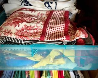 Pine armoire filled with linens (tablecloths, runners, napkins, and placemats) and fabric remnants