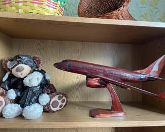 Wooden plane model and aviator pilot teddy bear with bomber jacket.