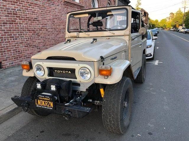 Toyota FJ40 with 107,000 miles. This vehicle is equipped with a custom V6 engine and a lifted suspension. It comes with both a hard top and a bikini top and features a Yeti cooler rack. The original beige exterior is complemented by a black interior. This FJ40 has a manual transmission and is in excellent overall condition. transmission and is in excellent overall condition.