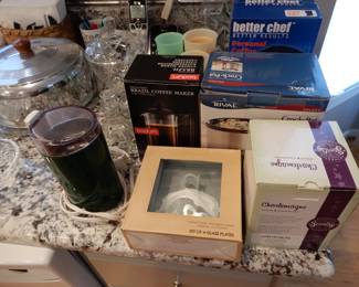 A VERY FULL KITCHEN WITH ALL SORTS OF POTS AND PANS, SILVERWARE AND RVRY UTENSIL YOU CAN THINK OF