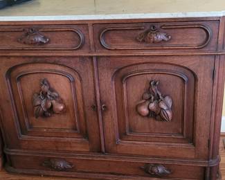 Antique marble top sideboard with fruit carvings and bottom drawer, belonged to the homeowner's parents