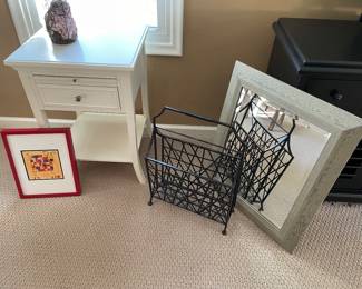 
White nightstand with drawer and lower tier, metal magazine rack, framed mirror,
and framed print