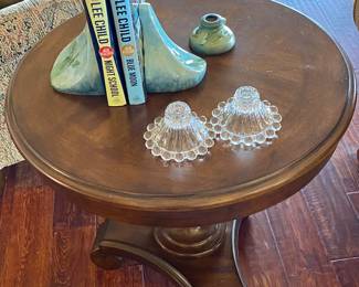 Excellent round wood end table with Roseville bookends.