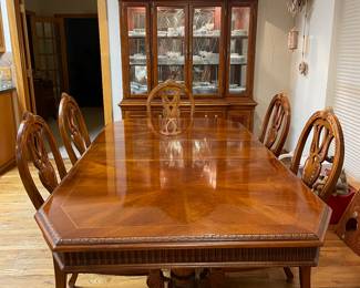 Dining table includes a leaf and heat protective cover.