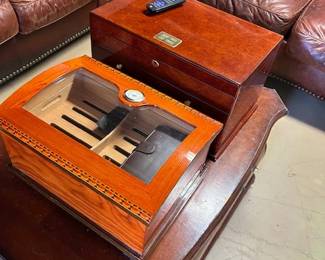 Two beautiful humidors, one full of quality cigars, sitting on exceptional coffee table