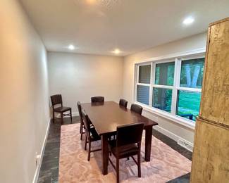Dining table with 7 leather chairs (World Market). Pink rug. Photos taken before sale set-up.