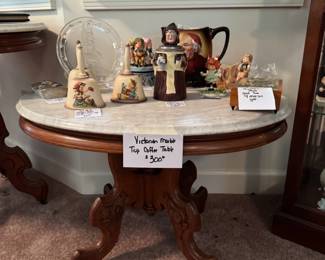 Oval marble top table with Goebel Monks and Hummel items