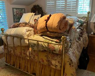 This queen-sized bed has LOTS of available bedding piled high on top of it.