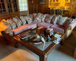 This picture shows a glass-topped coffee table, a corner sofa (excellent for the pillow-lovers!), and several books (some of which are first editions).  There is a matching chair and footrest to the sofa.