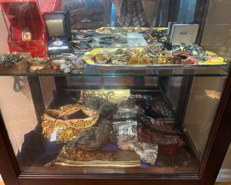 It looks like a vintage Disney watch in the red case.  There are some hats for fancy occasions on the bottom shelf.