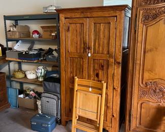 And a metal shelving unit next to a smaller armoire.  Yes, those are a pair of folding wood chairs.