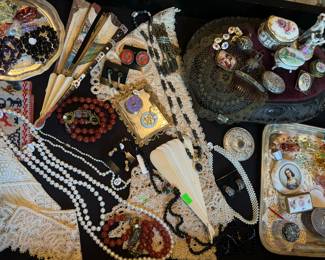 Antique fans, Antique silver rattle, antique silver chatelaine perfume shell, antique metal thread lace, Antique trinket boxes, Semi-Precious and gold bead necklaces, Pearl necklaces, Vintage Murano glass miniature animal figurines, Silver trinket box, Sewing Sampler from 1890, Antique lace collars