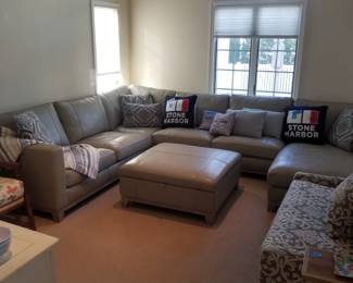 Gorgeous gray leather sectional couch with matching storage ottoman