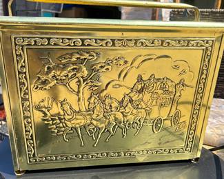 Brass magazine holder featuring covered wagon motif.