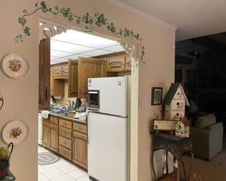 Looking into the kitchen. wicker plant stand, bird houses