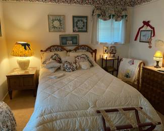 The guest room has hand framed doilies, handmade lamp shade on vintage lamp, cushions, handmade Sun Bonnet Sue guilt, guilt rack, luggage rack