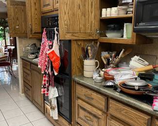 Looking into the kitchen, crocks, lots of utensils including vintage, pans, hand mixer