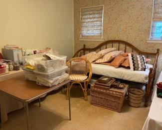 The sewing/craft room is still a work in progress, but lots of fabric and sewing notions, wicker chair and wicker storage trunk, framed shell art