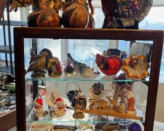 This display case contains Seasonal items, vintage photographs, and tin types, purple insulators, cameras, Fenton plate
