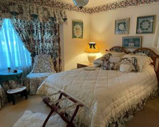 Guest room with  Laura Ashley fabric window treatments, table cloth, and chair covers