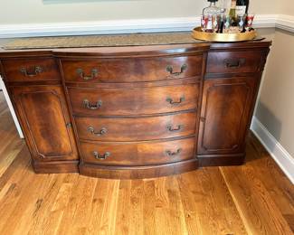 Circa 1940 A brilliant piece by White Furniture Company. Made from Crotch Mahogany with a serpentine front. Features 6 drawers over 3 lower cabinets. 2 of the upper drawers are felt lined with partitions for silverware storage.  56x22x35