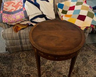 Many cool quilts and small tables.