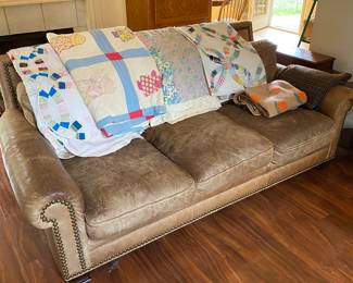 Leather couch flanked with nice old quilts. Someday it will get cold again and people will remember how nice it is to have a warm old quilt to put accross their legs.